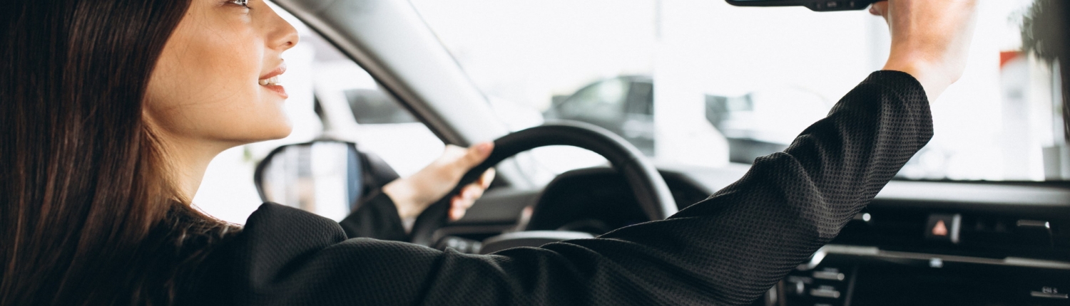 Young woman testing a car in a car showroom