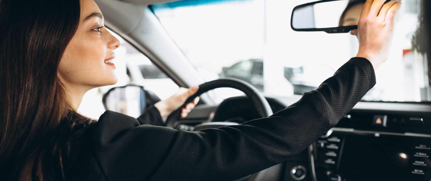 Young woman testing a car in a car showroom